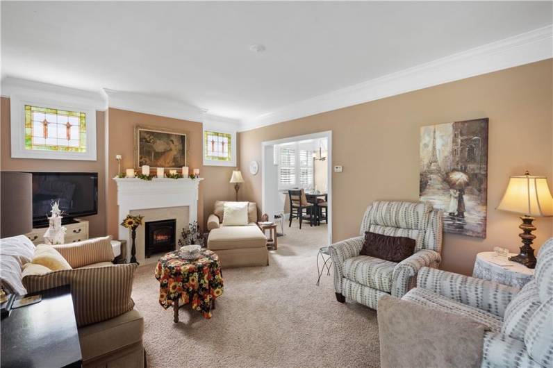 The living room features a cozy fireplace and is open to the dining room. Lovely stained glass windows flank the fireplace. This room opens to the multi purpose room or dining room.