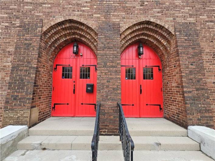 Enter the church through the intricate red doors.