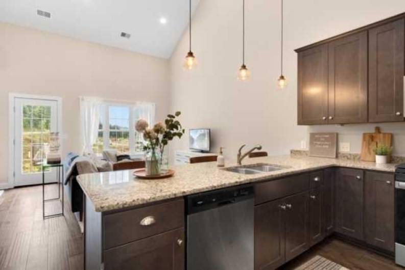 Open concept kitchen has sit up breakfast bar at peninsula.