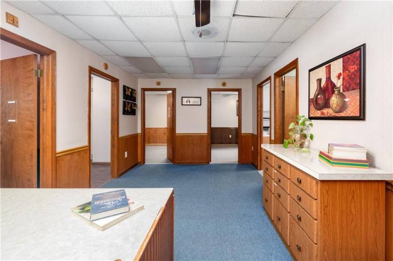 Reception area surrounded by offices, bathroom and kitchenette.