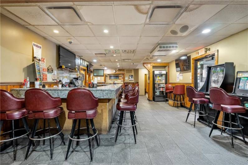 View of the bar looking towards the entrance to dining (straight ahead in photo) and separate entrance for bar patrons (right of photo).  Multiple entertainment games thru vending service (Agreement will transfer with sale if desired by new owner)