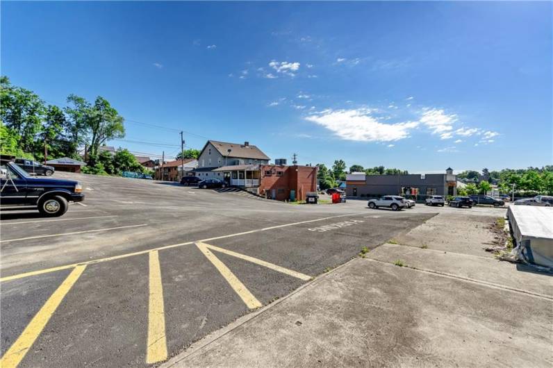 Building and right side parking area as viewed from right rear corner of property