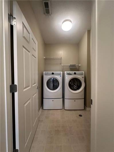 1st Floor Laundry with newer washer and dryer on pedestals.
