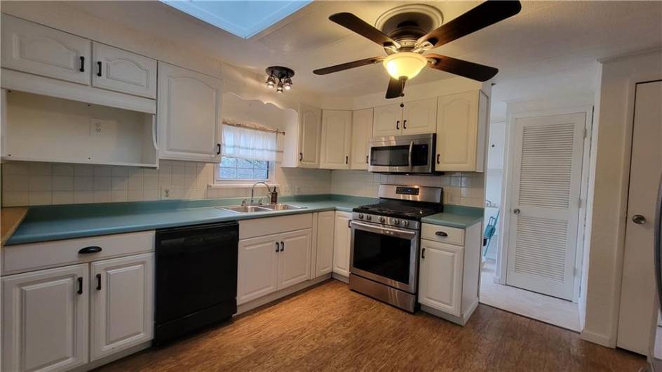 Lots of counter space and cabinets in the crisp kitchen.  The window over the sink looks out into the back yard.