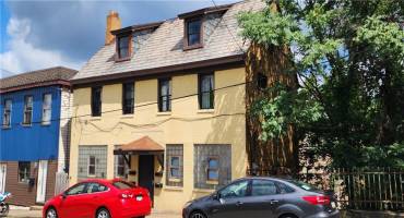 Solid brick 4 unit building with two car garage at rear of building. Vacant adjacent lot included.