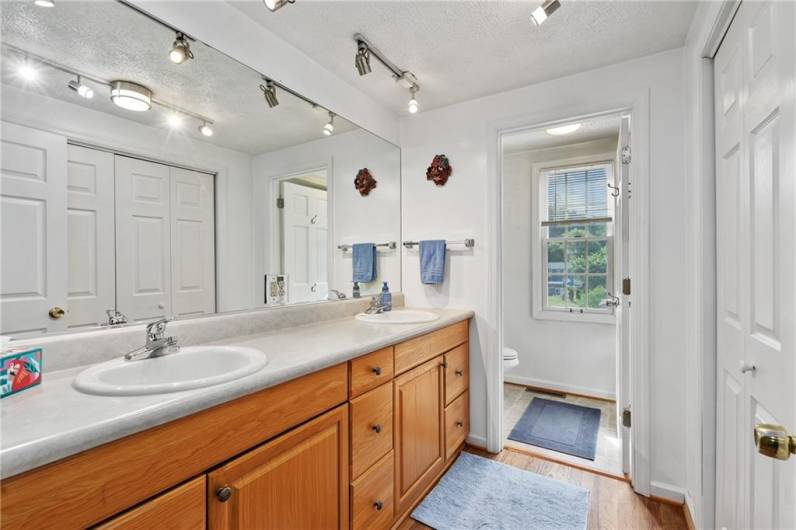 upper level full bathroom has double vanity and a large closet