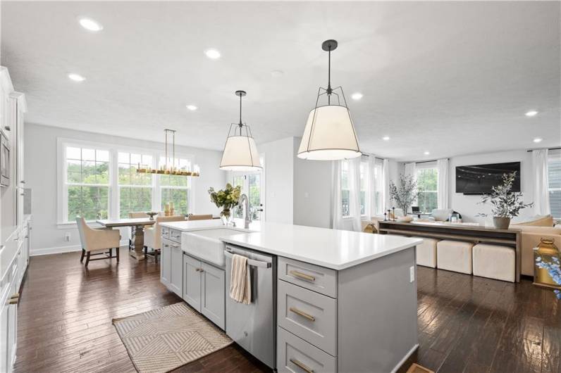 The luxurious Kitchen boasts a huge island, quartz countertops, modern white cabinetry, wall ovens & a beverage station.