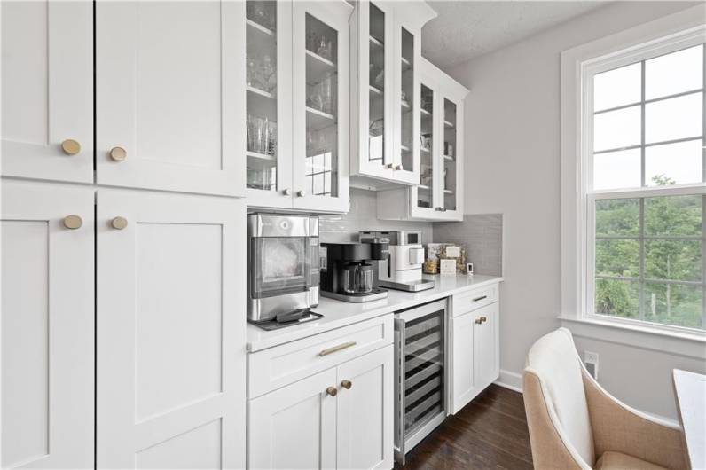 The luxurious Kitchen boasts a huge island, quartz countertops, modern white cabinetry, wall ovens & a beverage station.