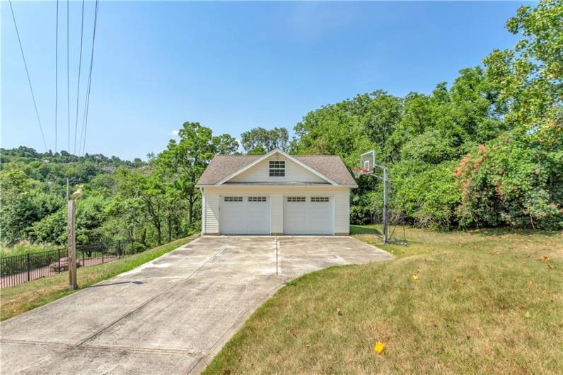 Detached garage on upper level has it's own driveway and permanent basketball hoop.