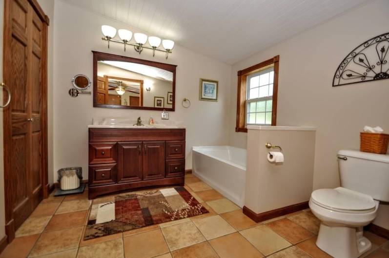 This bathroom has ceramic floors, nice size tub for soaking.