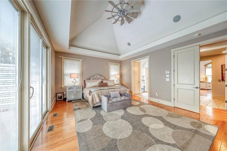 First floor primary suite has vaulted ceiling, hardwood floors, sliding door to added deck and built-in hot tub.  The   primary closet offers built-ins