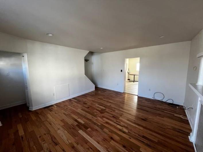 Alternate view in the living room shows the laundry closet to the left by the entry and the steps leading upstairs to the left of the kitchen entryway.