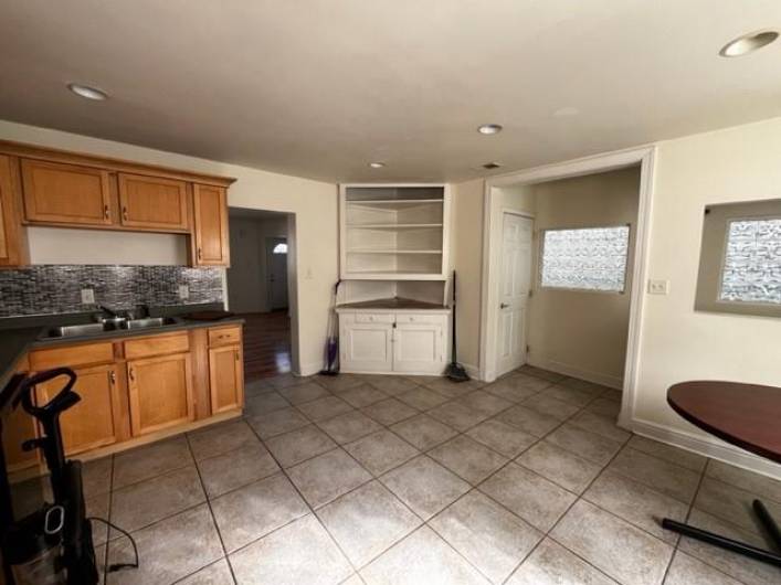 Open doorway in the center leads to the living room.  The closed door leads to the basement.