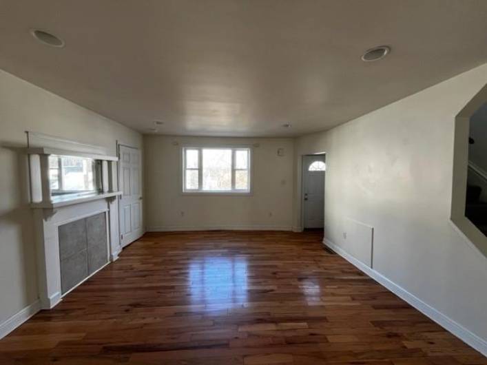 Living room as seen from the kitchen doorway.  Gleaming refinished hardwood flooring. The laundry is located across from the entry door  in the far right of the photo.  The door to the far left is the closet.