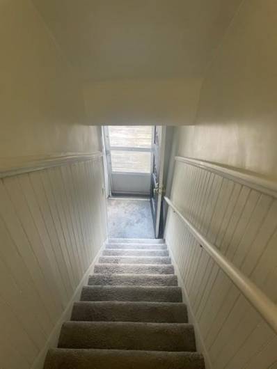 Steps off the main floor hallway lead down to the back deck entrance.  To the left is a door to the bedroom that also has a full bath.