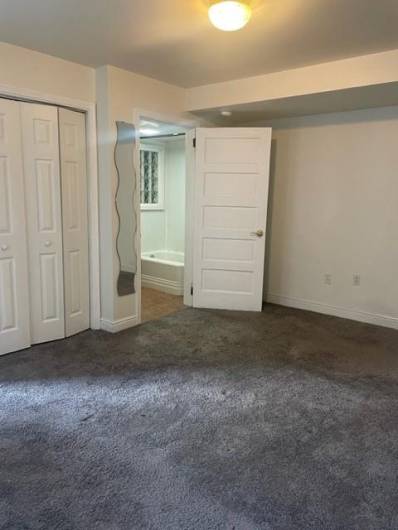 Alternate view of lower level  bedroom with door open to the attached full bathroom.