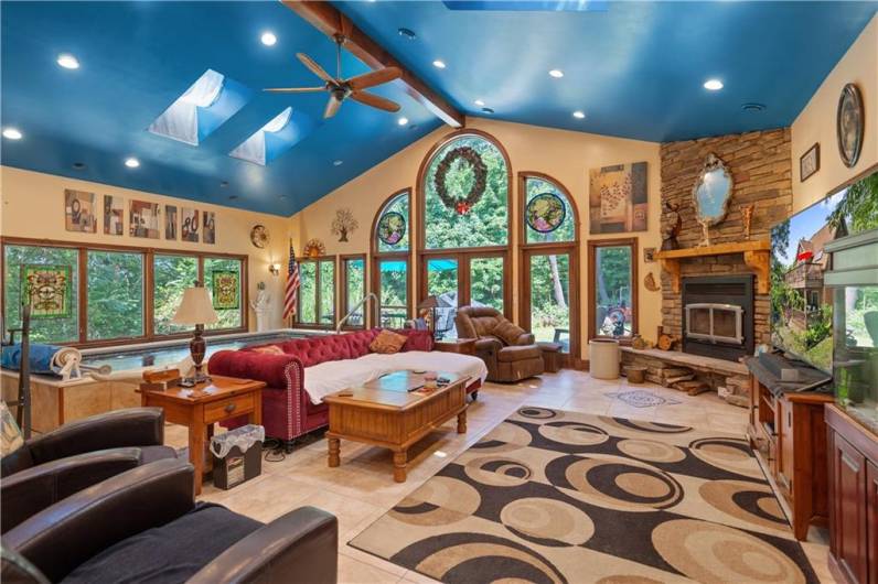 Floor to Ceiling Stone Fireplace and so many windows to enjoy the outdoor beauty that surrounds the home