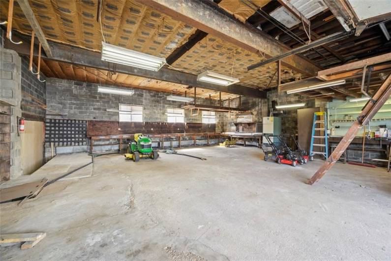 View of main building garage looking in from from the garage door. There is a built in workbench along the back wall.