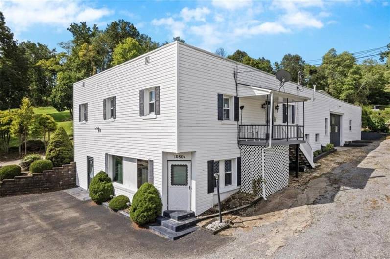 The primary building includes a commercial space on the lower level and an apartment on the upper level. The covered porch on the upper level is access to the apartment.
