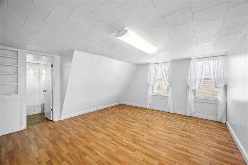 Entering the living room of the small house, the bathroom is to the left. New vinyl flooring has just been installed.