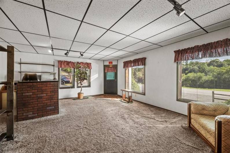 Alternate view of the lower level front reception area and/or front office space. It features several large windows.