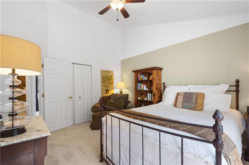 The second bedroom has a large window and a vaulted ceiling.