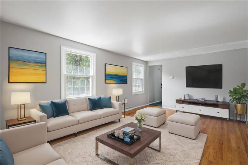 The Living Room is light and bright and has hardwood floors. Virtually staged photo to illustrate what is possible!