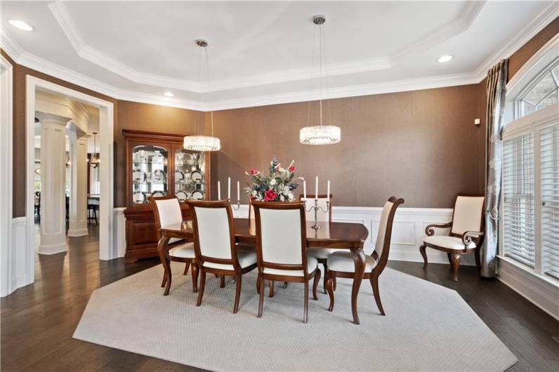 The large formal dining room has tray ceiling, crown molding, & chair rail