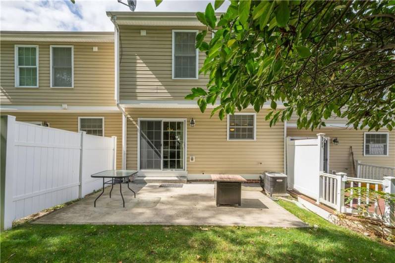 Spacious back patio with plenty of sunlight for relaxing or grilling.