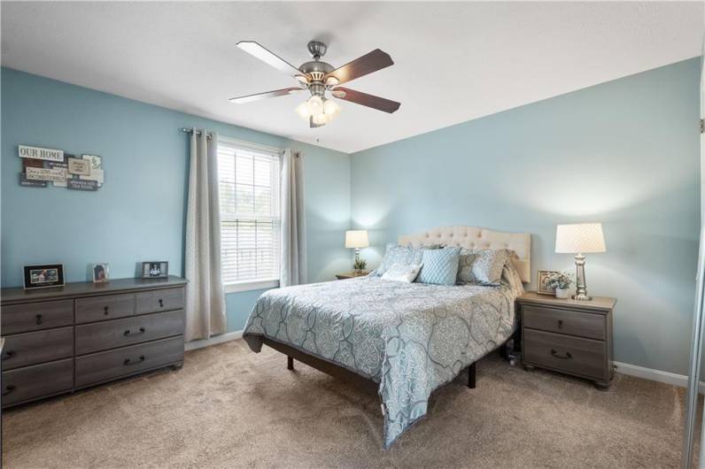 Modern and spacious primary bedroom with plenty of natural light and overhead lighting.