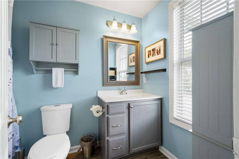 Modern primary bathroom with lots of storage and beautiful flooring.