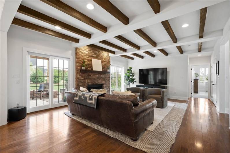 Stunning wood beam ceiling accents, stone gas fireplace, 2 sets of doors leading out to the Patio.