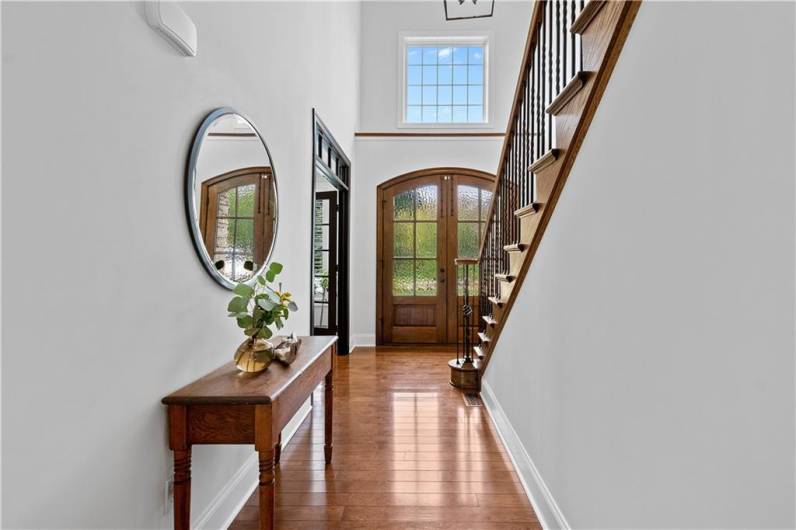 Gorgeous double door entry with soaring ceilings. Stunning walnut hardwood flooring throughout paired with custom baseboards and crown molding.