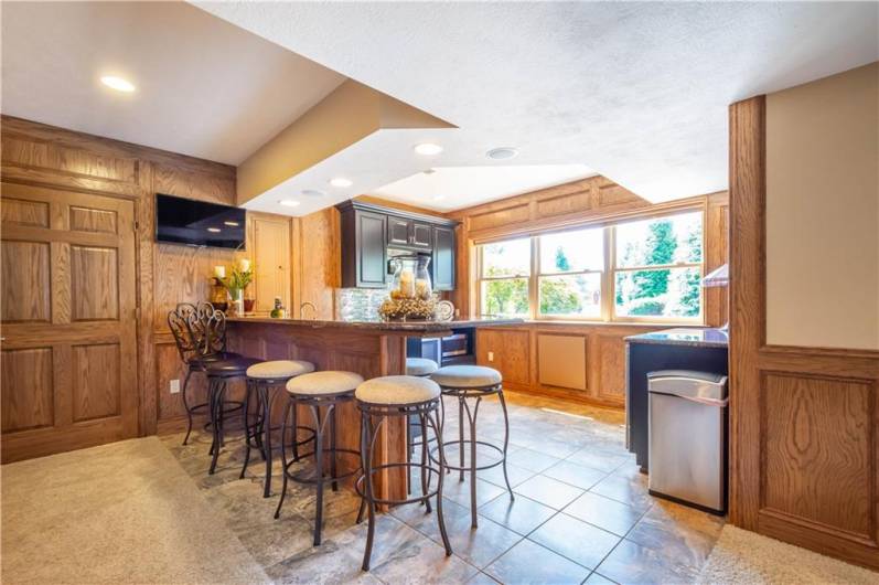 The walk-behind bar/kitchenette features a Beveridge refrigerator, oven, microwave and  large windows that serve as a pass-thru when entertaining outdoors.