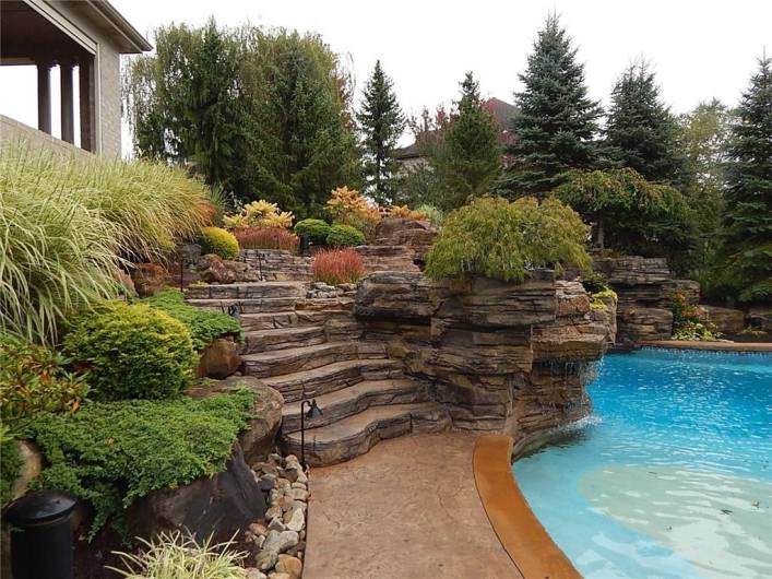 Lush landscape further enhance the stone work around the salt water pool.