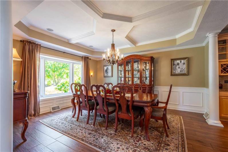 Specialty tray ceilings, wainscot paneling and large windows accentuate the dining room.  A convenient wet bar/butler's pantry is adjacent.