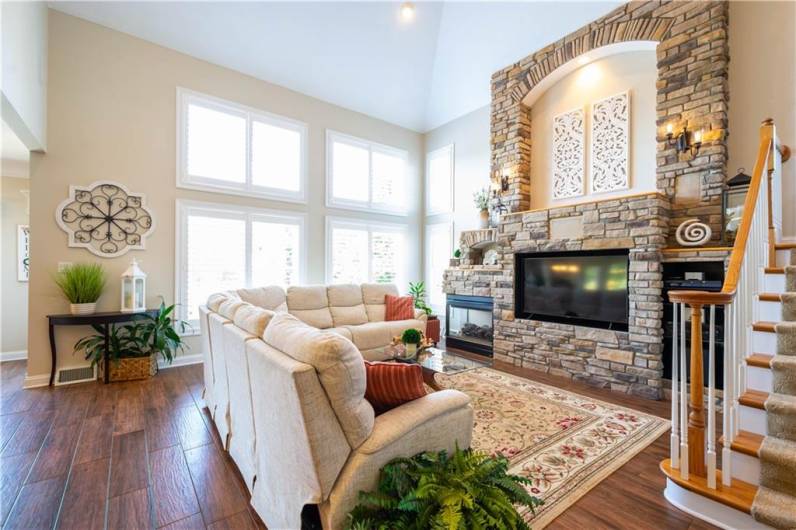 The two story great room features a stone accent wall with fireplace and built-in TV area.  The TV is included.