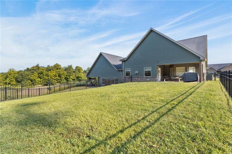 Enclosed spacious yard with black wrought iron fencing