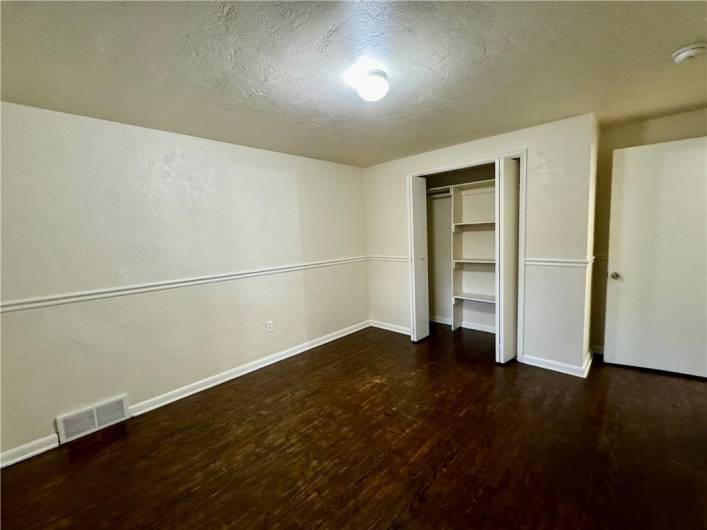 One of two original bedrooms with hardwood floor