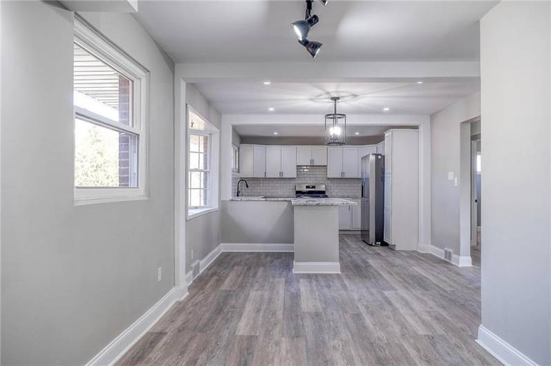 DININGROOM FACING THE KITCHEN. RECESSED LIGHTING, NATURAL LIGHT AND EASY TO CARE FOR LUXURY VINYL FLOORS.