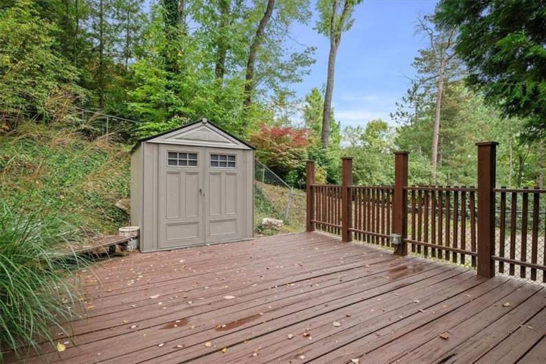 The spacious backyard deck, perfect for outdoor entertaining, includes a convenient storage shed tucked nearby, offering ample space for tools, equipment, or seasonal items.