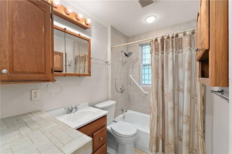 Updated bath with newer cabinetry and tiled shower/tub.