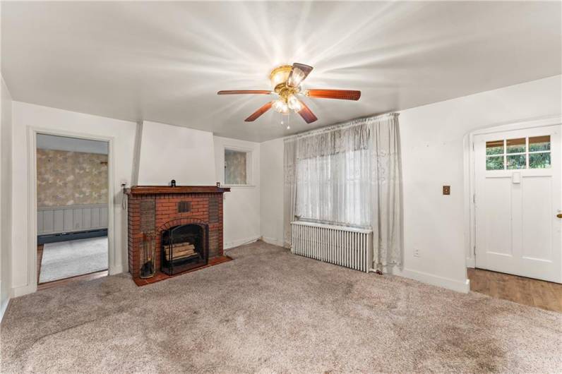 Living Room, anchored by a cozy fireplace. Formal entry with large coat closet to the right.