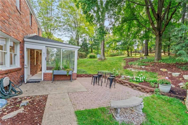 The Brick Patio is Surrounded by Tidy Landscaping and a Gravel Space for a Fire Pit or Grilling.