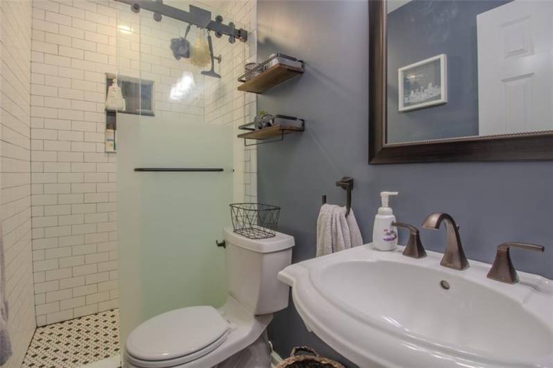 The primary bathroom was fully updated in 2018 with pedestal sink,lighting and a new glass shower door.