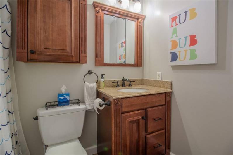 The 2nd full bath off the 2nd floor hallway has maple vanity and cabintes.