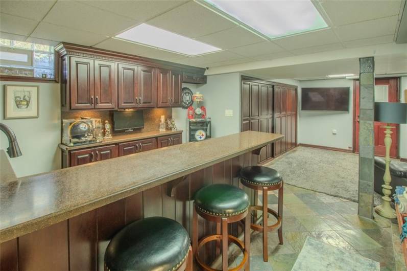 The wet bar has a Wolf electric cooktop,dishwasher,garbage disposal, beverage center and a drop down remote control television from the cherry cbaintes.