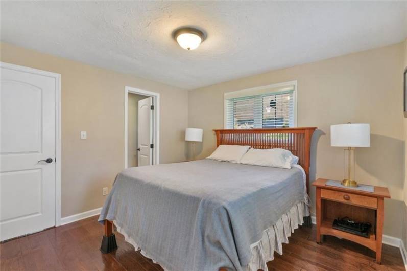 The primary bedroom is spacious with custom engineered hardwood flooring.