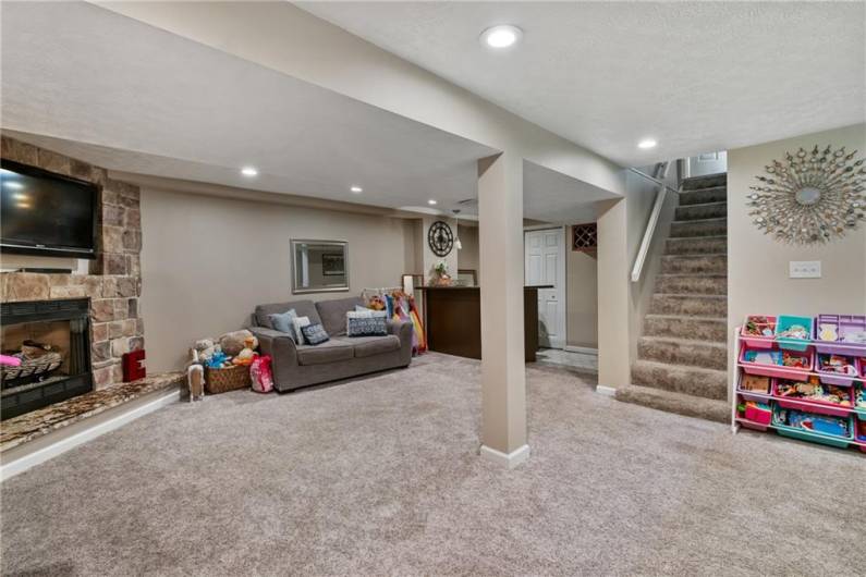 Huge finished walk out game room with recessed lighting and newer carpet.