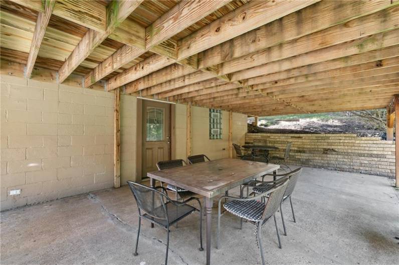 Large concrete patio with door from game room under deck.  Brand new versa lock retaining wall.